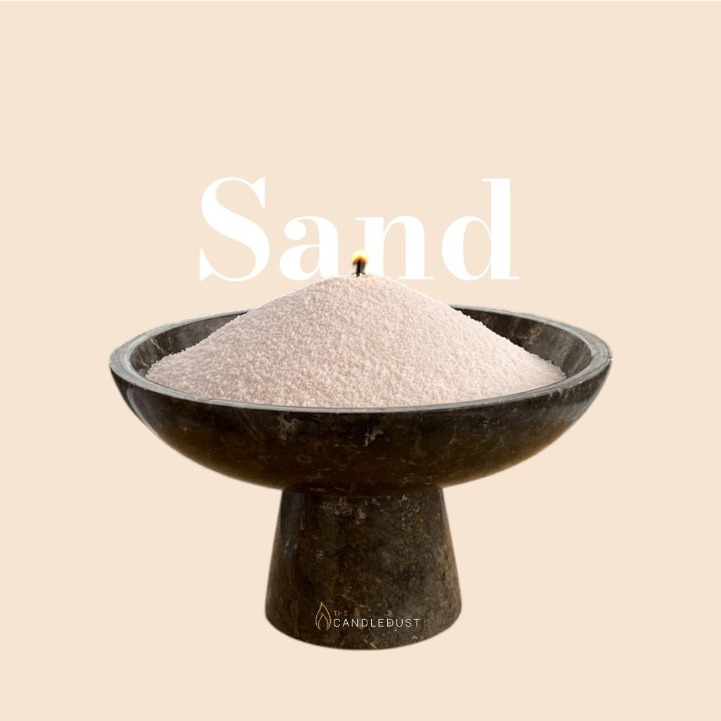 4. Flat lay of Candledust powdered candle refill kit in a black bowl with sand texture, featuring brand logo and 'Sand' text on beige background