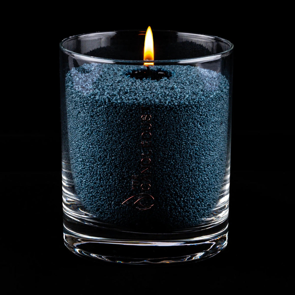 3. Space grey candle sand in glass container with lit wick on black background
