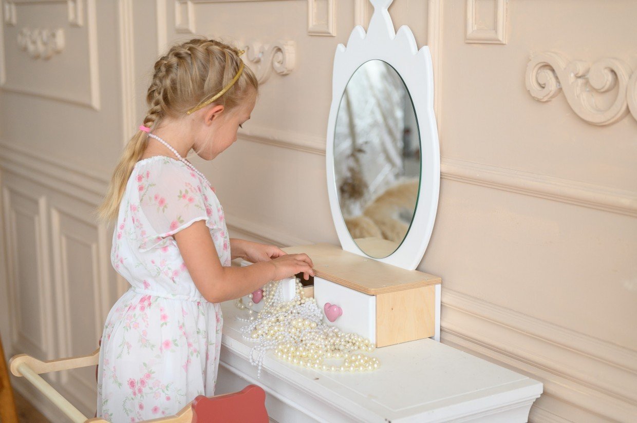 5. Young girl playing with jewelry at white princess beauty table with heart-shaped mirror