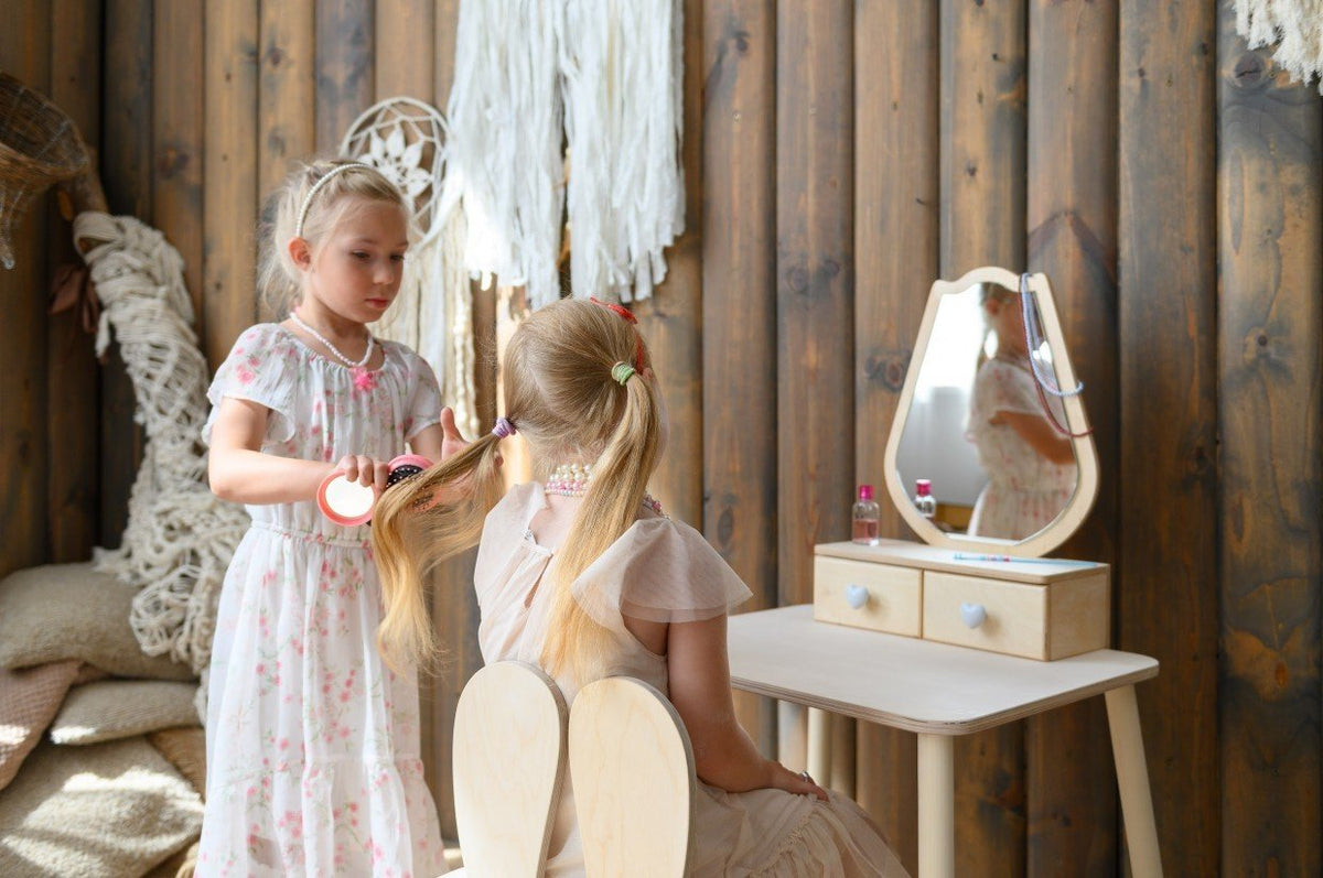 1. Two young girls playing with a white beauty table set in a cozy room, enhancing imaginative play.