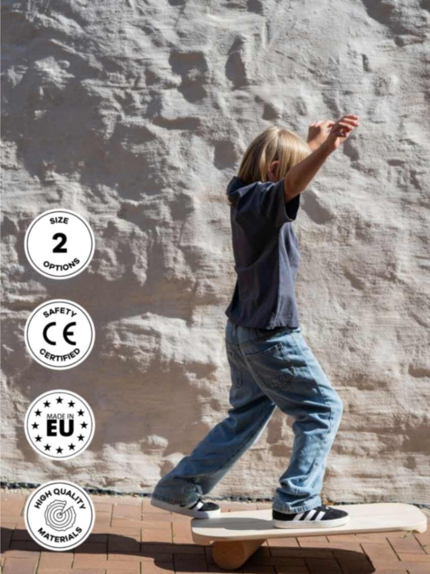 1. Child balancing on rectangular balance board with exercise roll against textured wall, wearing casual jeans and sneakers