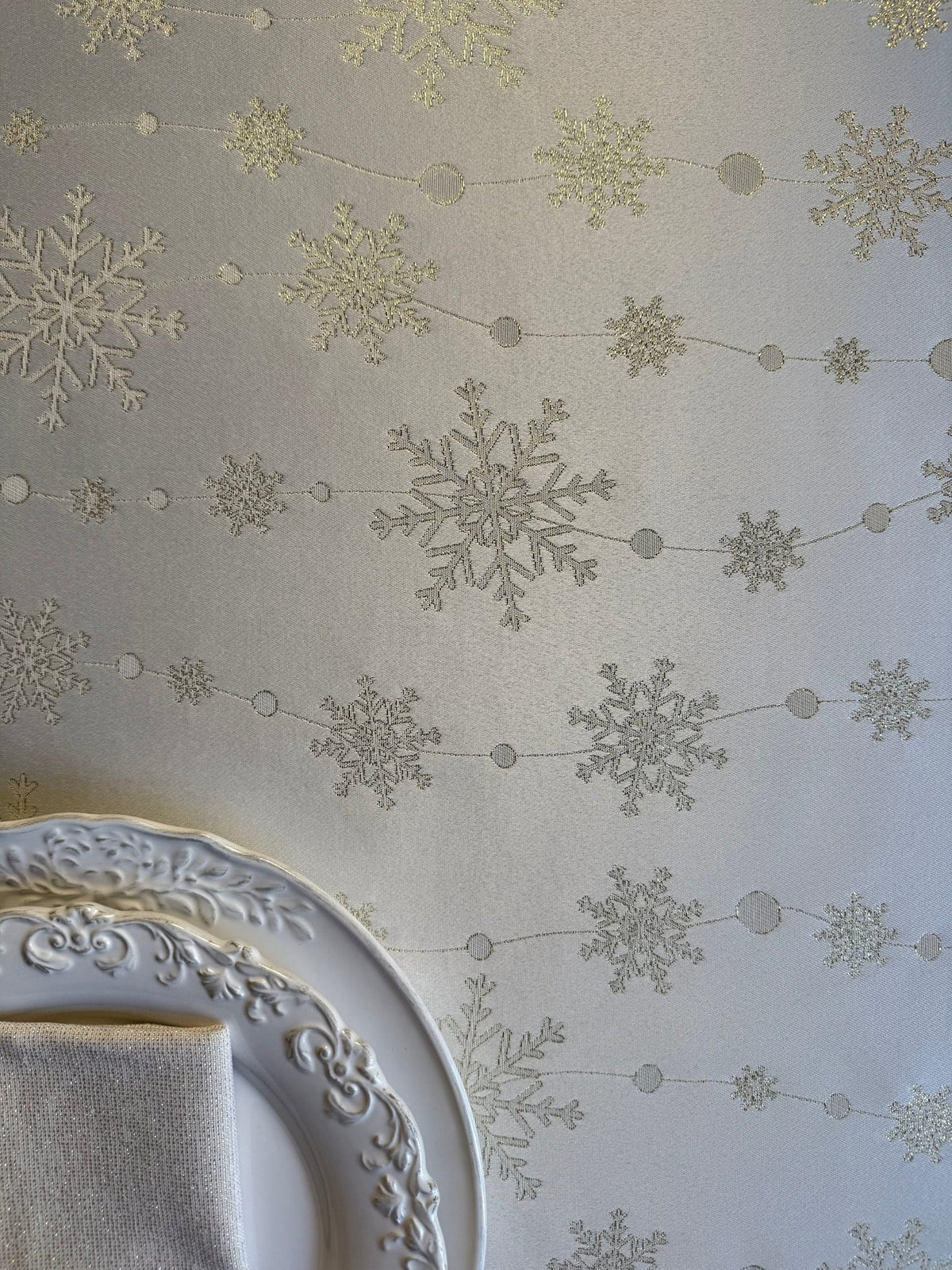 4. Flat lay of tablecloth with golden snowflakes and decorative plate in corner