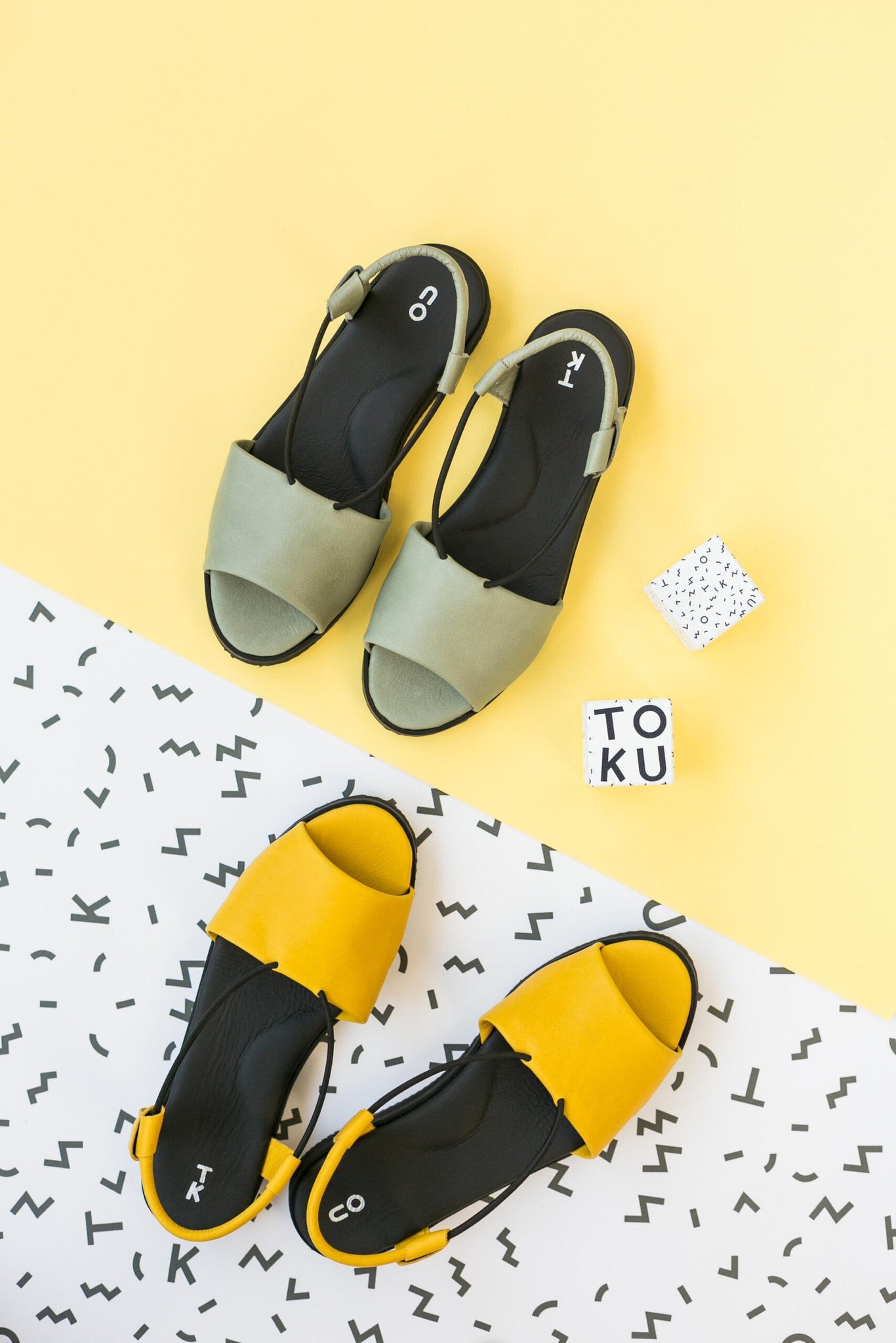 3. Flat lay of yellow and green Berlin sandals by Omaking, featuring playful design elements on a yellow and white background