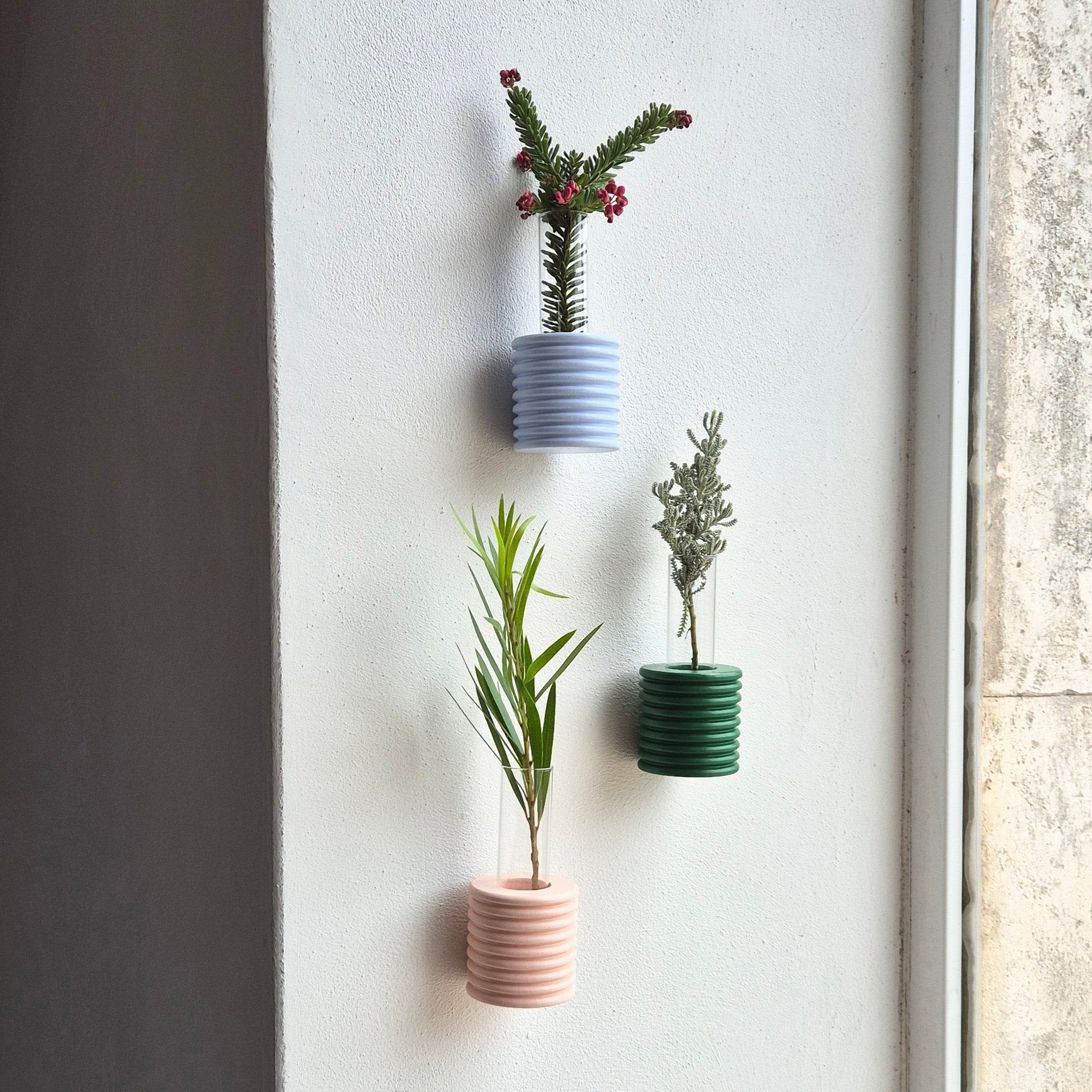 5. Group of Ribble Wall Vases in green, blue, and pink by 5mm Paper, displayed with plants on a wall, lifestyle setting