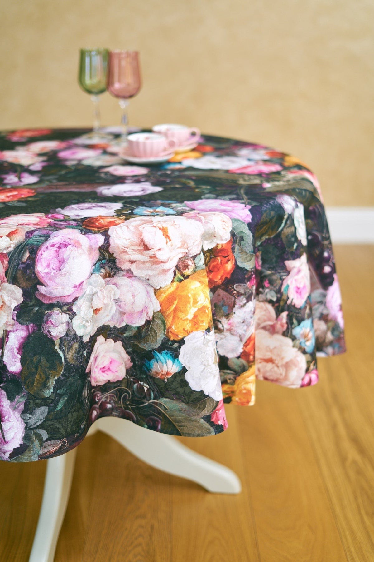 1. Round table with Francine black floral tablecloth, pink and green glasses, and pink teacup in elegant dining room setting