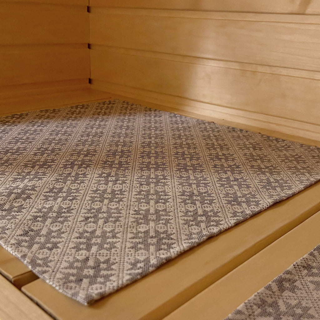 2. Close-up of LOKO sauna seating pad with Pärnu County mitten pattern on wooden bench