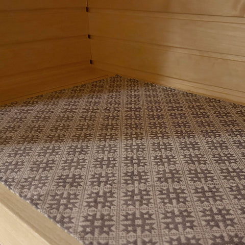 1. Sauna bench seating pad with traditional Pärnu County mitten pattern in a wooden sauna setting