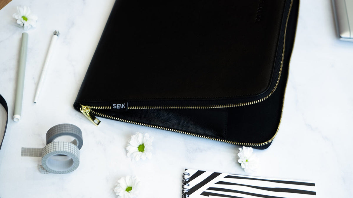 4. SEIK Dream.Plan.Do laptop sleeve partially open, displaying SEIK branding and gold zipper detail