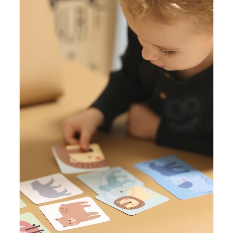7. Child examining animal cards from Shaky Tower game on a table