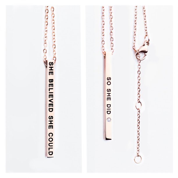 2. Close-up of Olla rose gold necklace with engraved 'She Believed She Could / So She Did' pendant, showing chain and clasp details