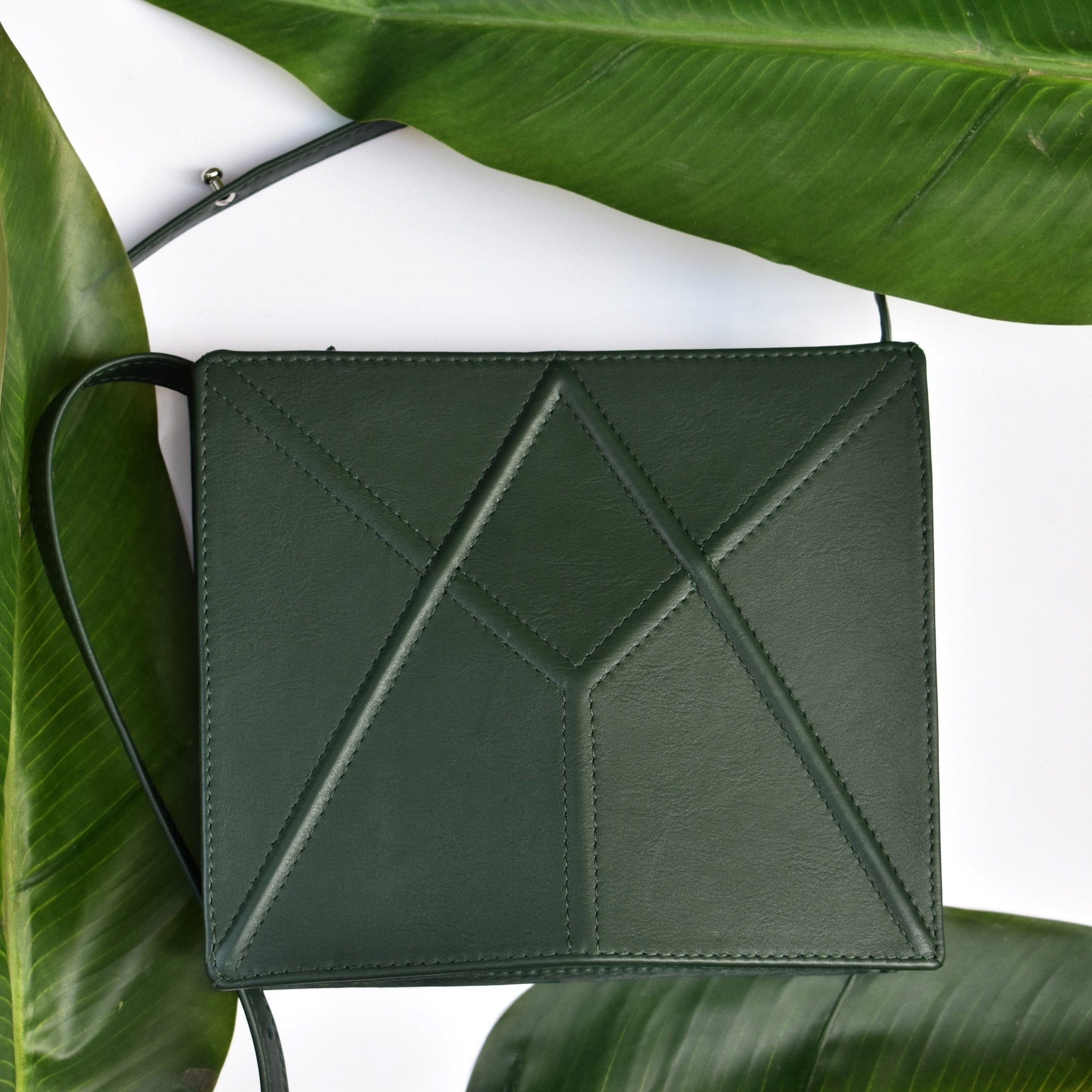 17. Green FACET shoulder bag by Gerda Retter Design, placed on green leaves in a lifestyle setting