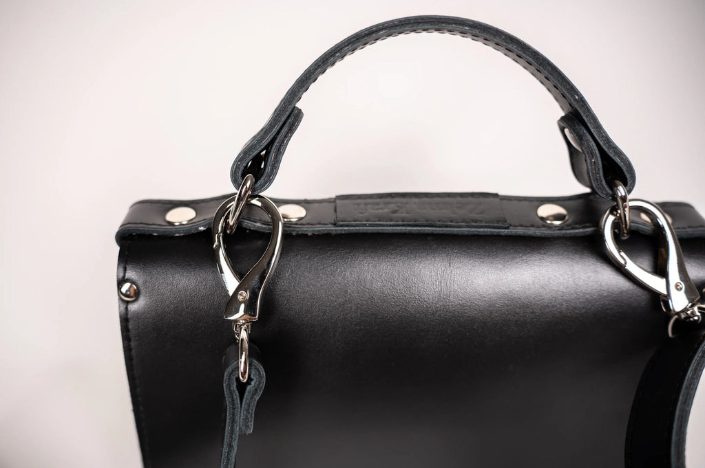 3. Close-up of Zelma Kraft black handbag handle and silver clasp detail