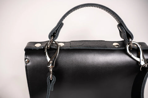 3. Close-up of Zelma Kraft black handbag handle and silver clasp detail
