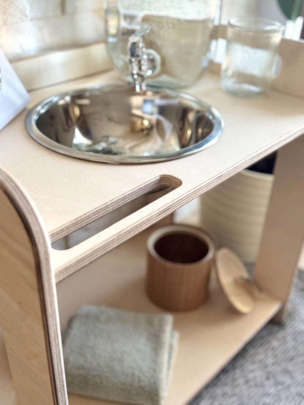 3. Close-up of wooden wash station with enamel bowl, towel, and wooden container on shelf