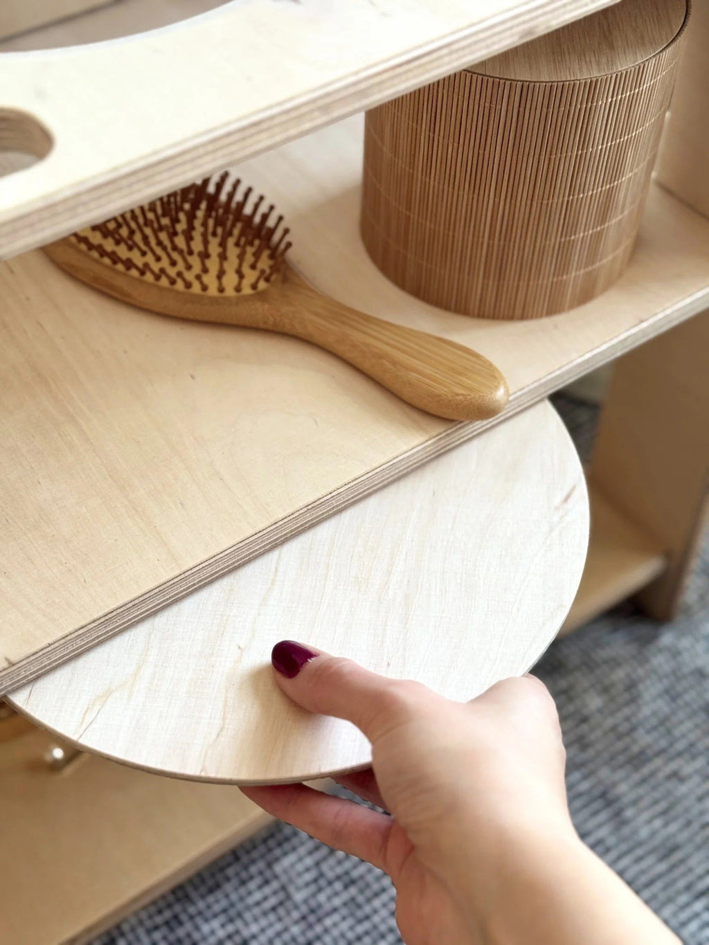 3. Close-up of hand placing lid on Montessori wash station shelf