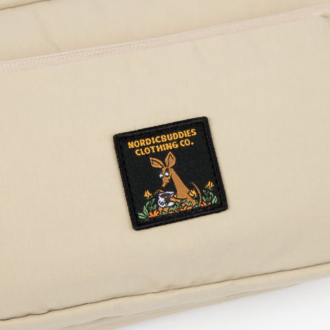 3. Close-up of Nordicbuddies Clothing Co. logo patch on beige Sniff Retro Waist Bag