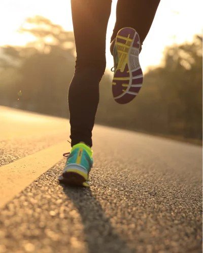 1. Person running on road at sunrise wearing colorful sneakers, highlighting active lifestyle