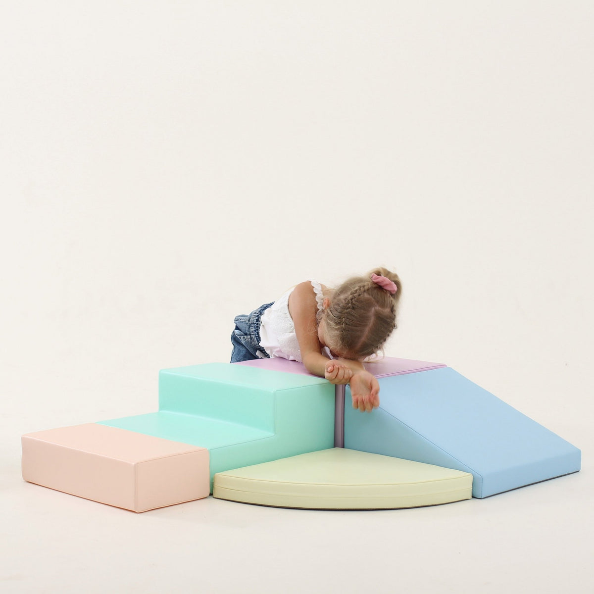 10. Girl resting on IGLU pastel foam block set with steps and ramp in a studio