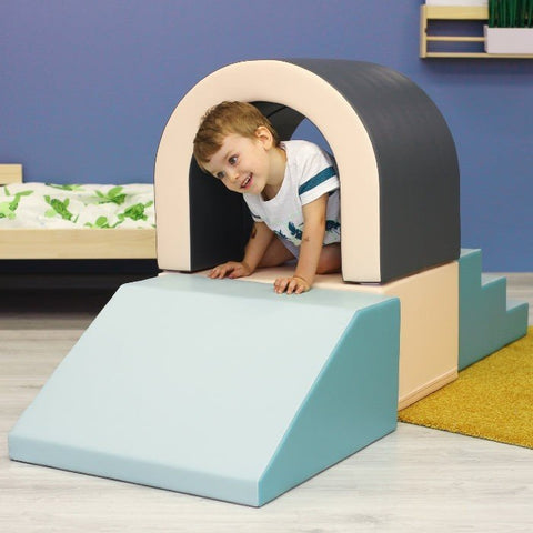 1. Boy crawling through IGLU pastel soft play tunnel set in indoor playroom