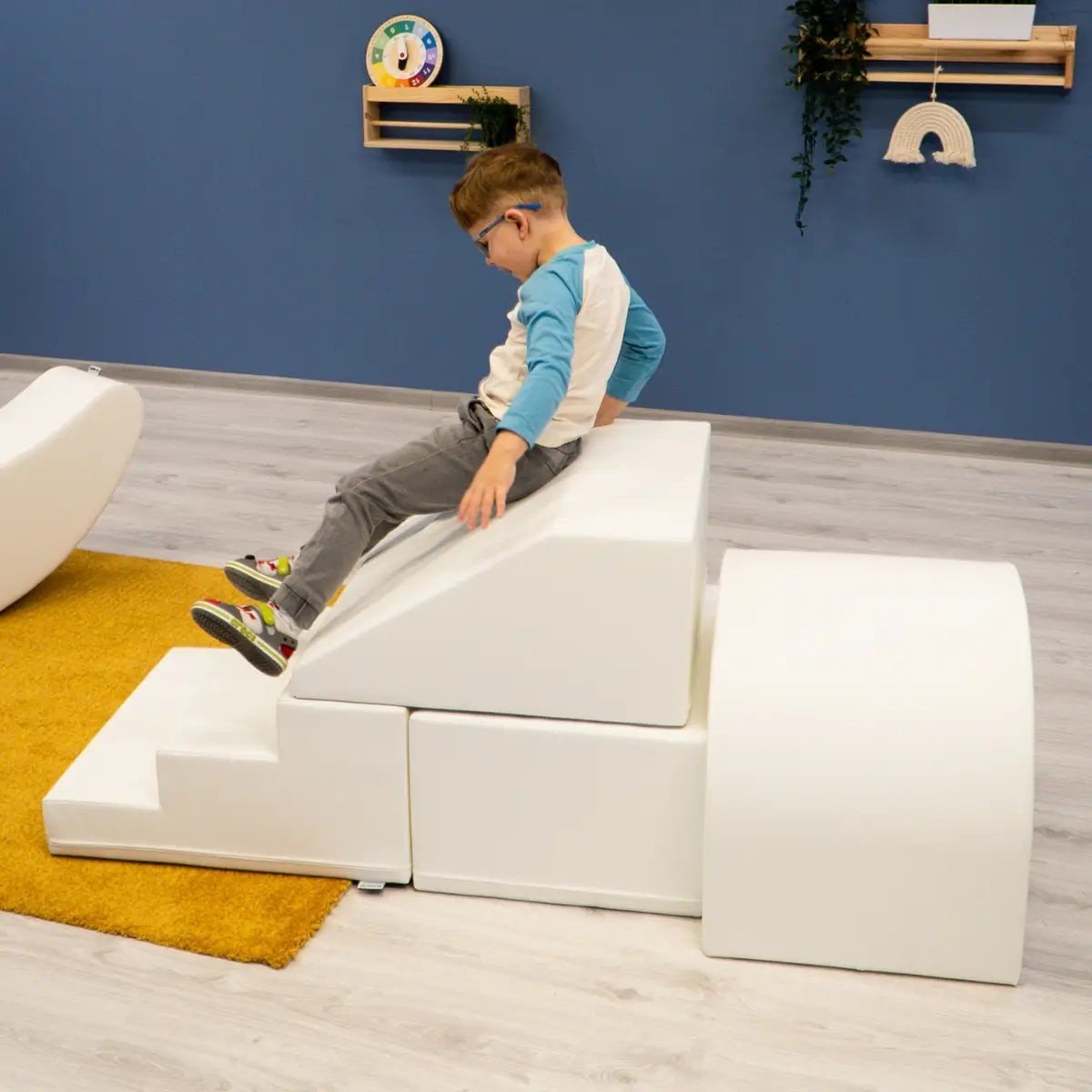8. Boy sliding down white IGLU soft play set with steps and ramp