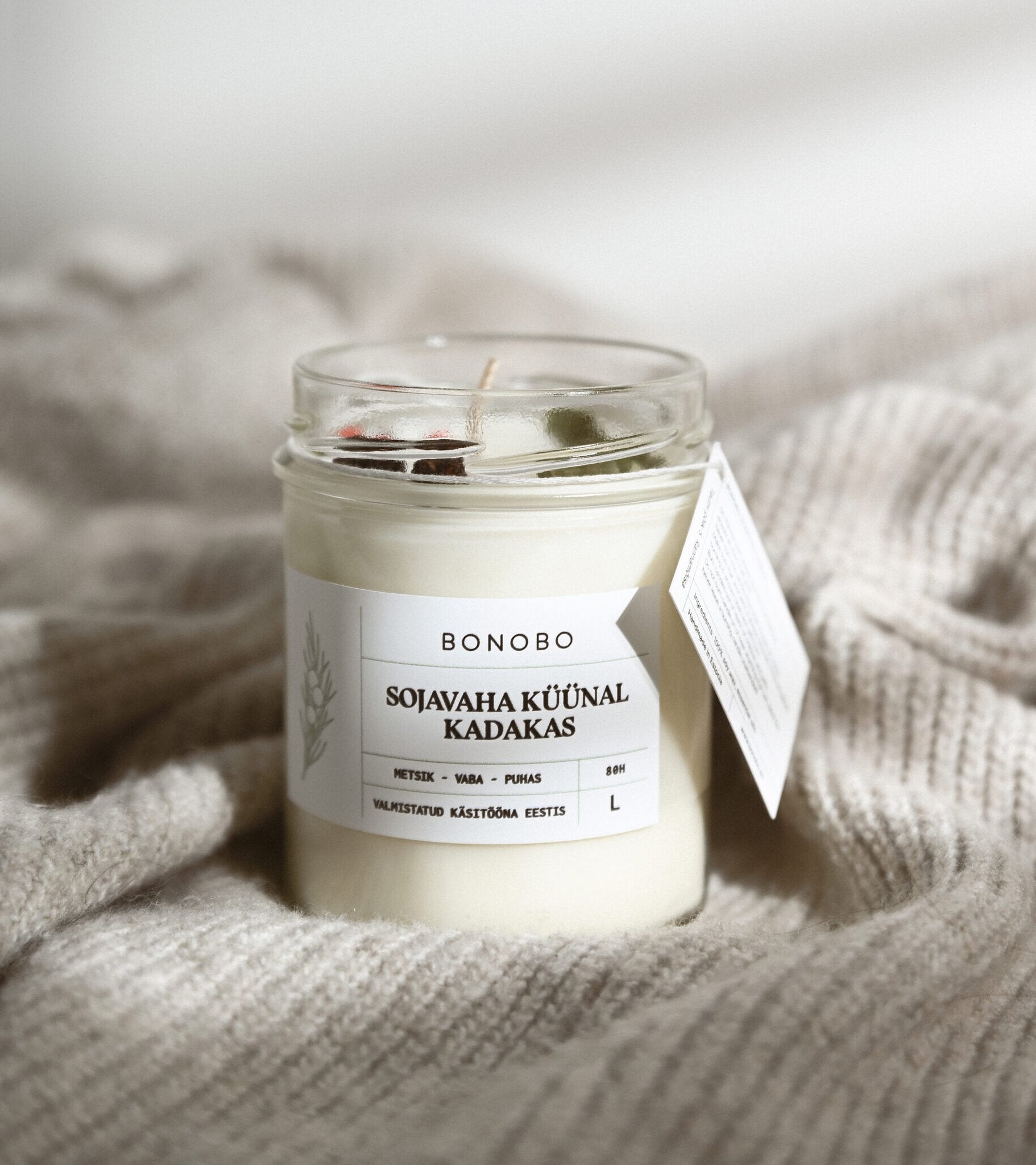 3. BONOBO juniper scented candle in a cozy setting, featuring soy wax and essential oils with label details