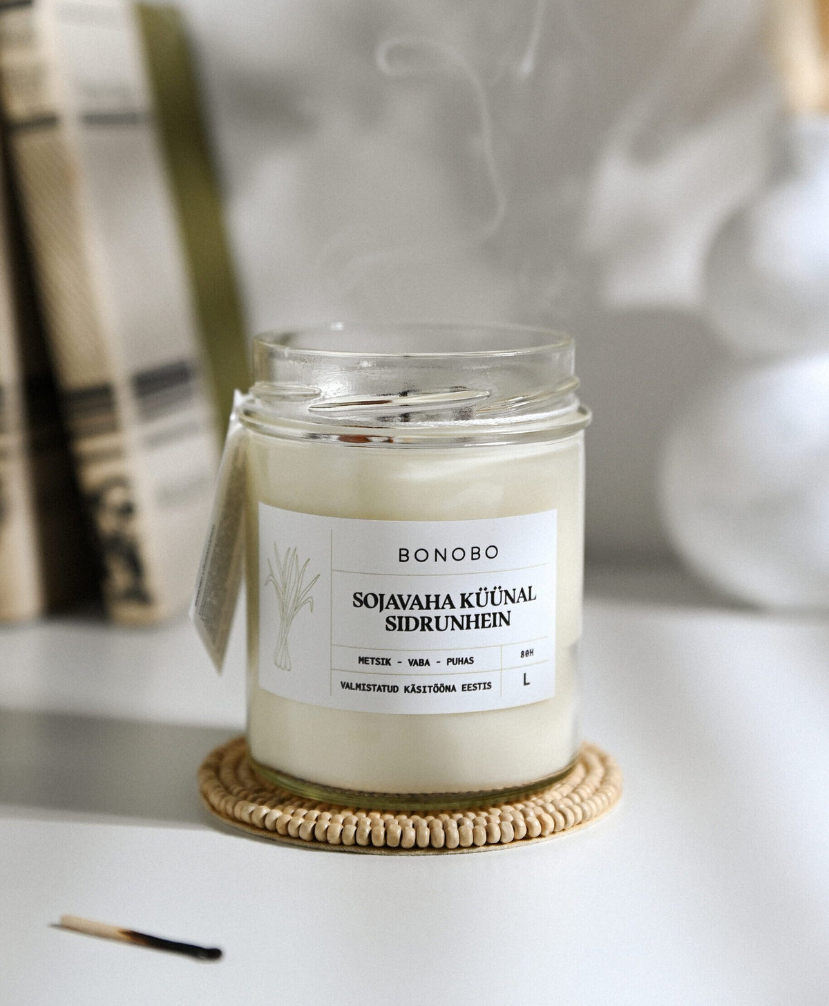 3. Bonobo lemongrass scented candle in a glass jar with smoke, highlighting eco-friendly soy wax