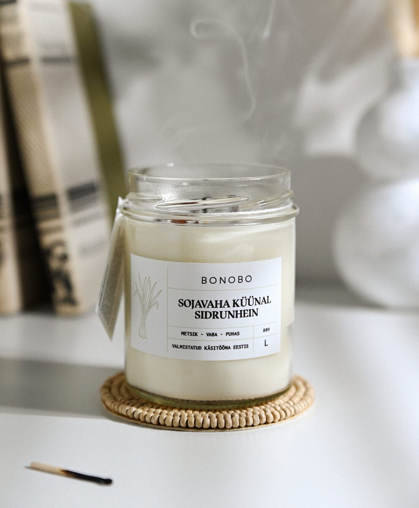 3. Bonobo lemongrass scented candle in a glass jar with smoke, highlighting eco-friendly soy wax