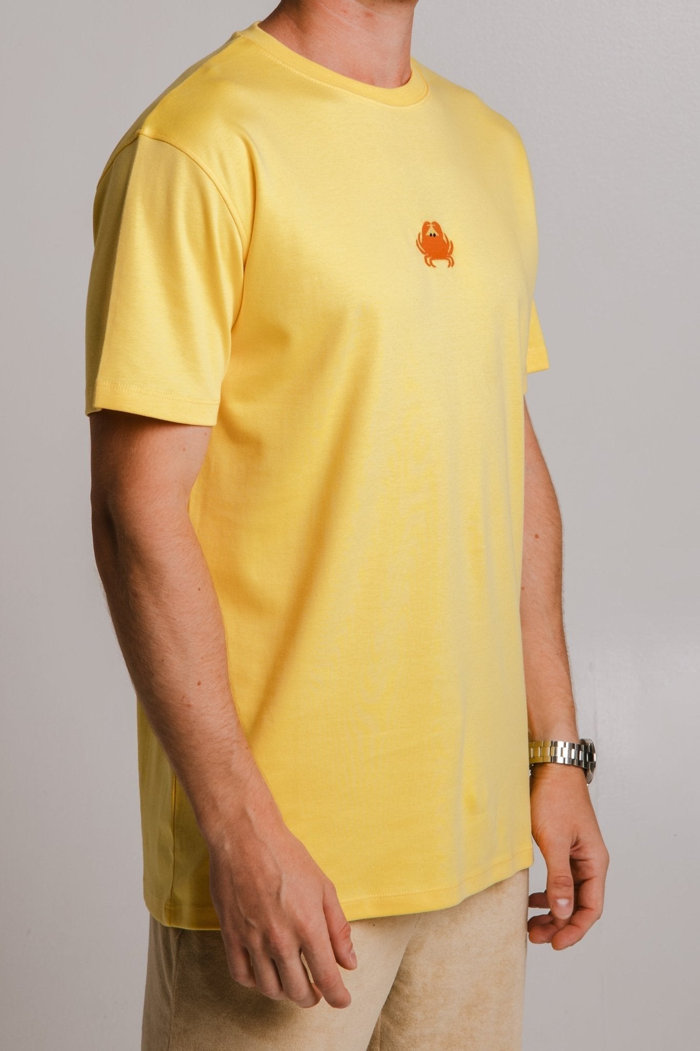 4. Close-up of Sossu's yellow Crab Heavy T-shirt showing crab logo detail