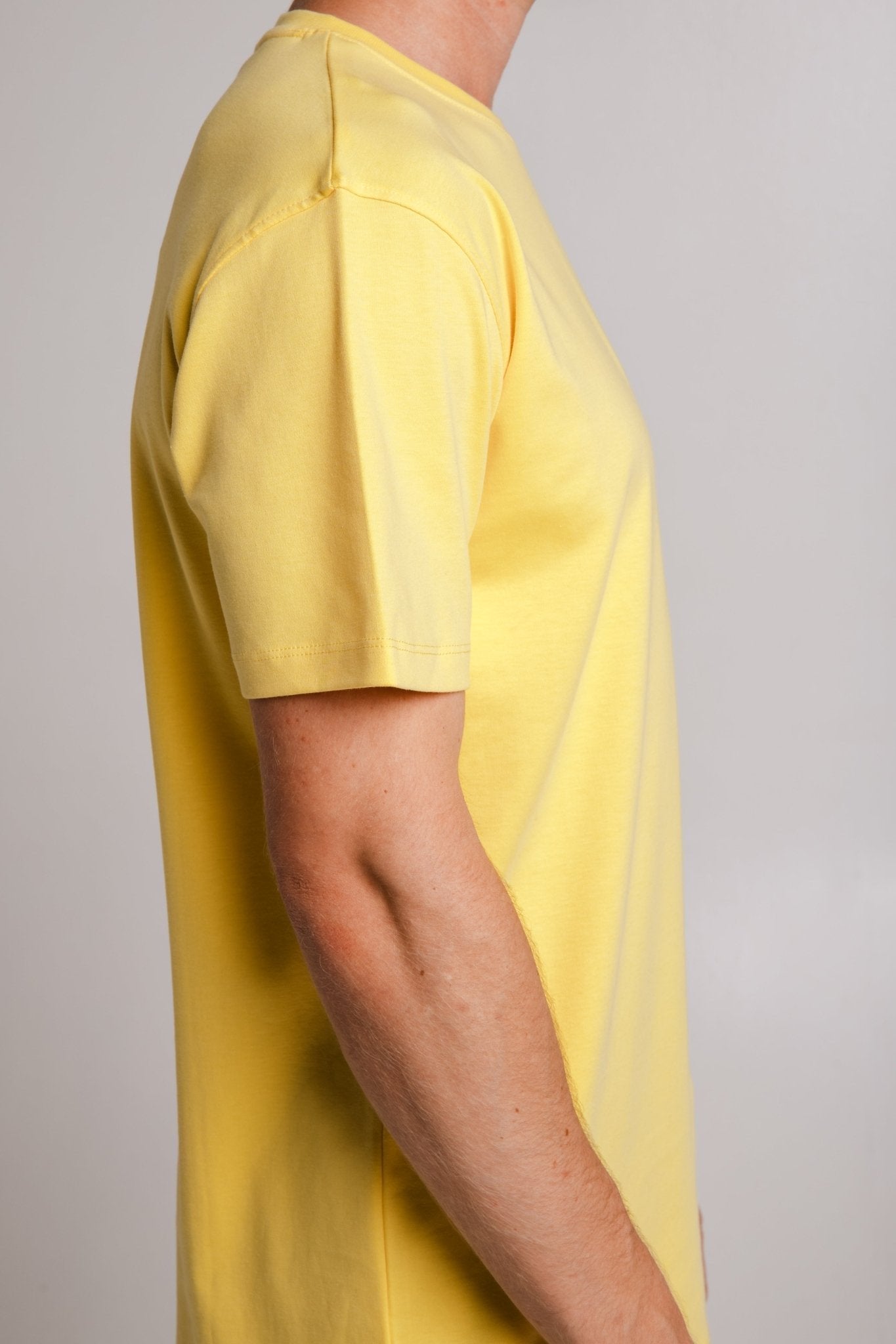 3. Side view of Sossu's yellow Crab Heavy T-shirt on male model, highlighting fit