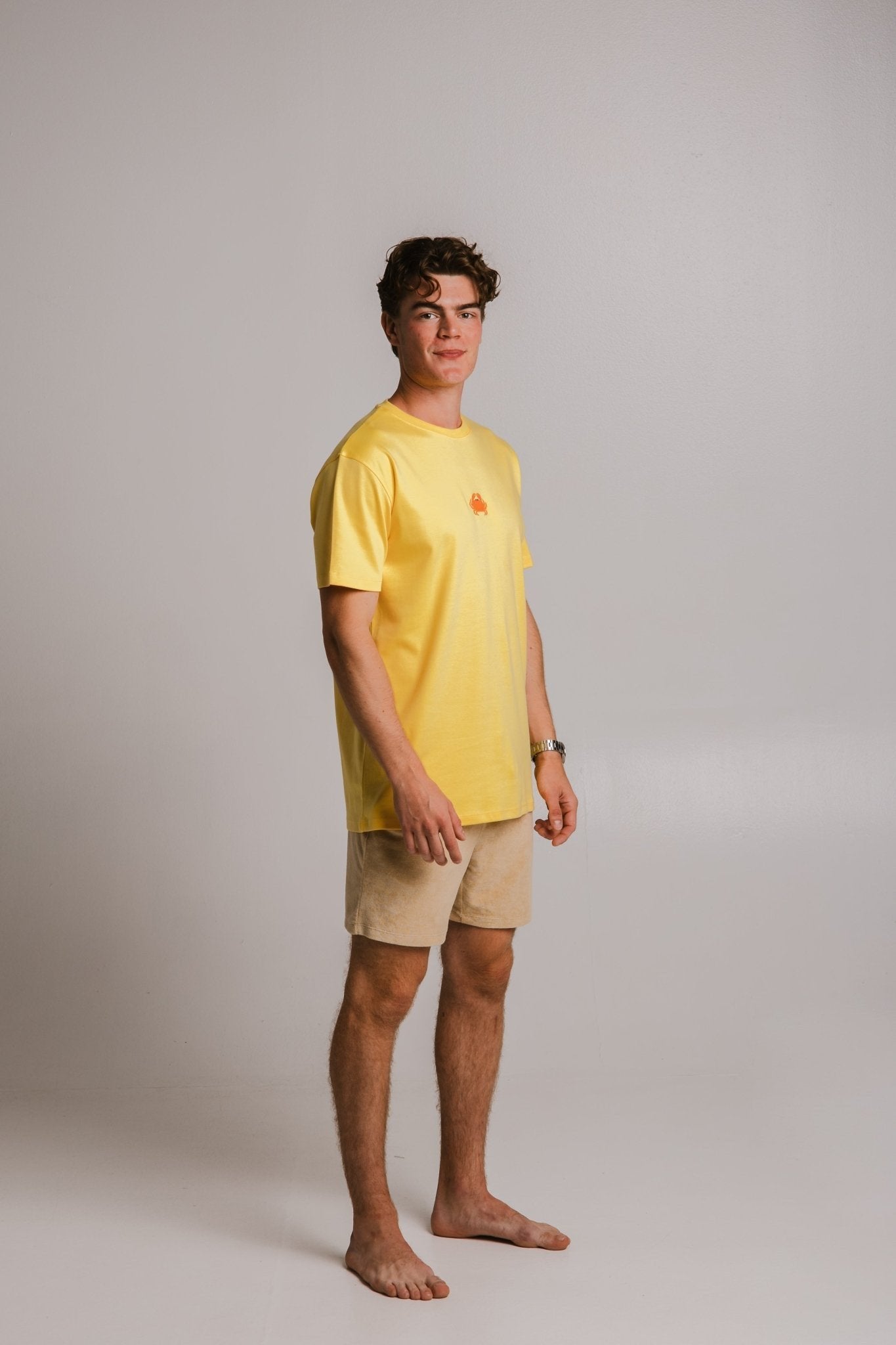 2. Full-body view of male model wearing Sossu's yellow Crab Heavy T-shirt in studio