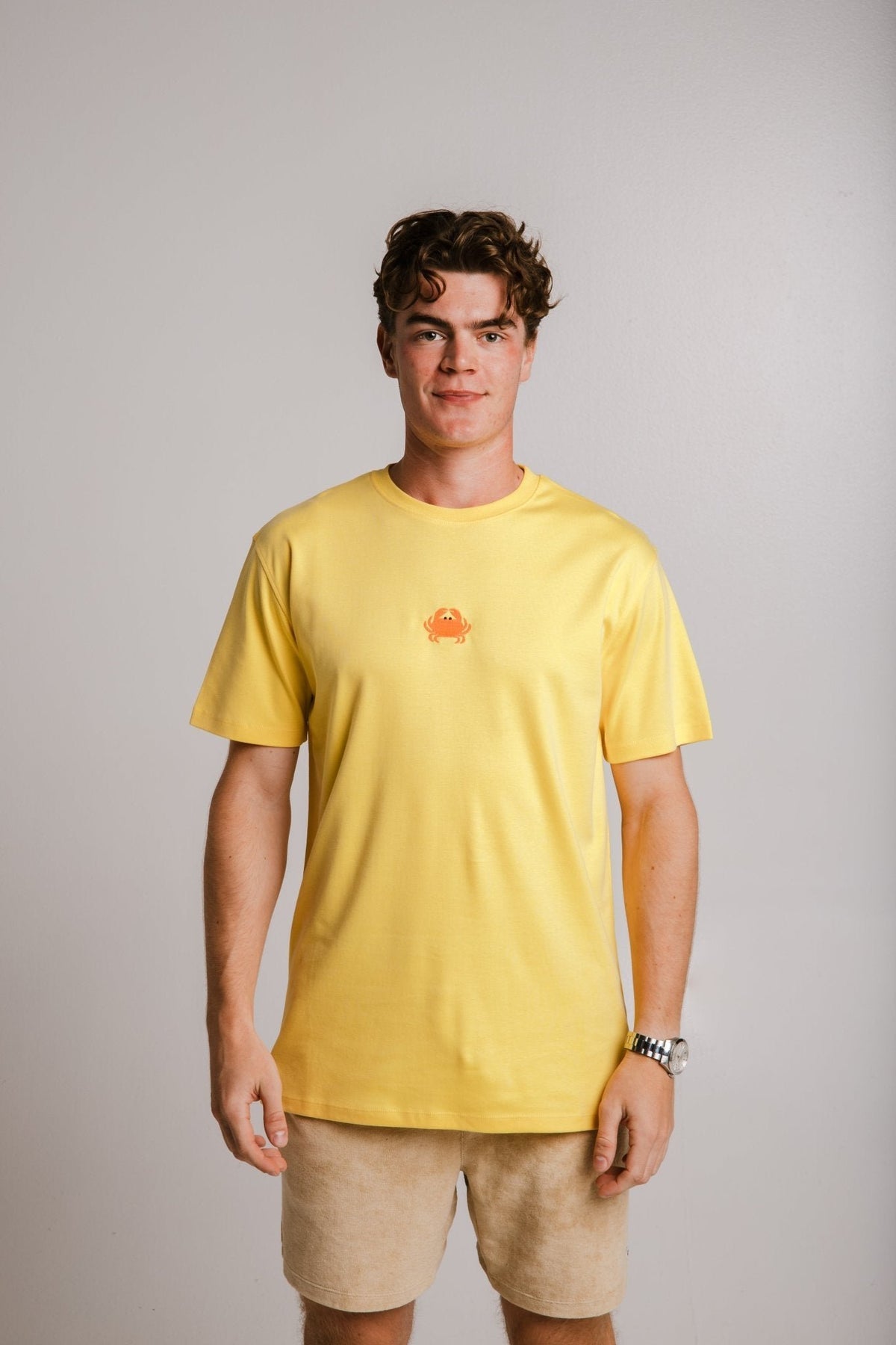 1. Unisex yellow Crab Heavy T-shirt by Sossu worn by male model in studio setting