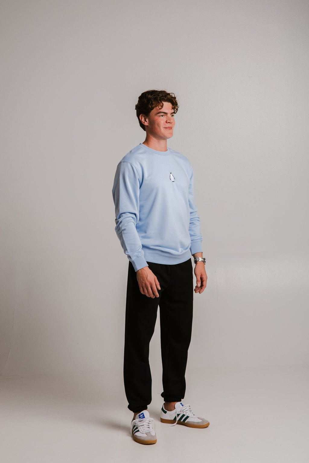 3. Full body view of male model wearing unisex light blue Emperor Penguin Soft Fleece Sweatshirt by Sossu