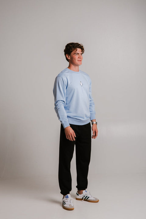3. Full body view of male model wearing unisex light blue Emperor Penguin Soft Fleece Sweatshirt by Sossu
