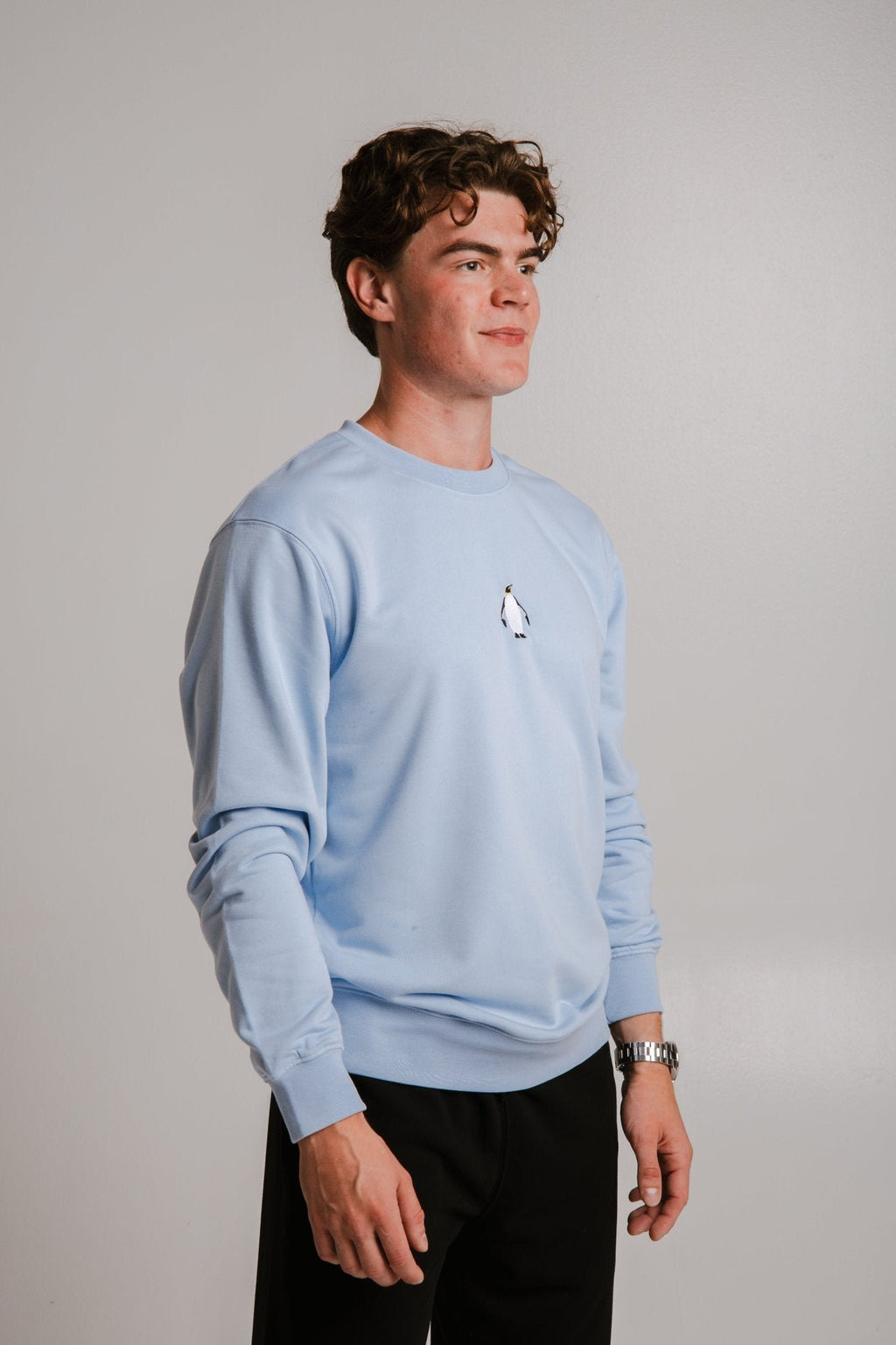 2. Side view of unisex light blue Emperor Penguin Soft Fleece Sweatshirt by Sossu on male model