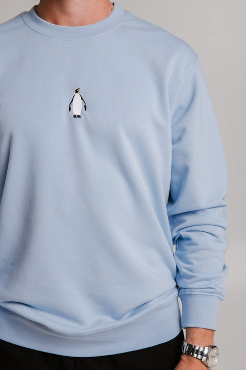 4. Close-up of unisex light blue Emperor Penguin Soft Fleece Sweatshirt by Sossu showing embroidered penguin detail