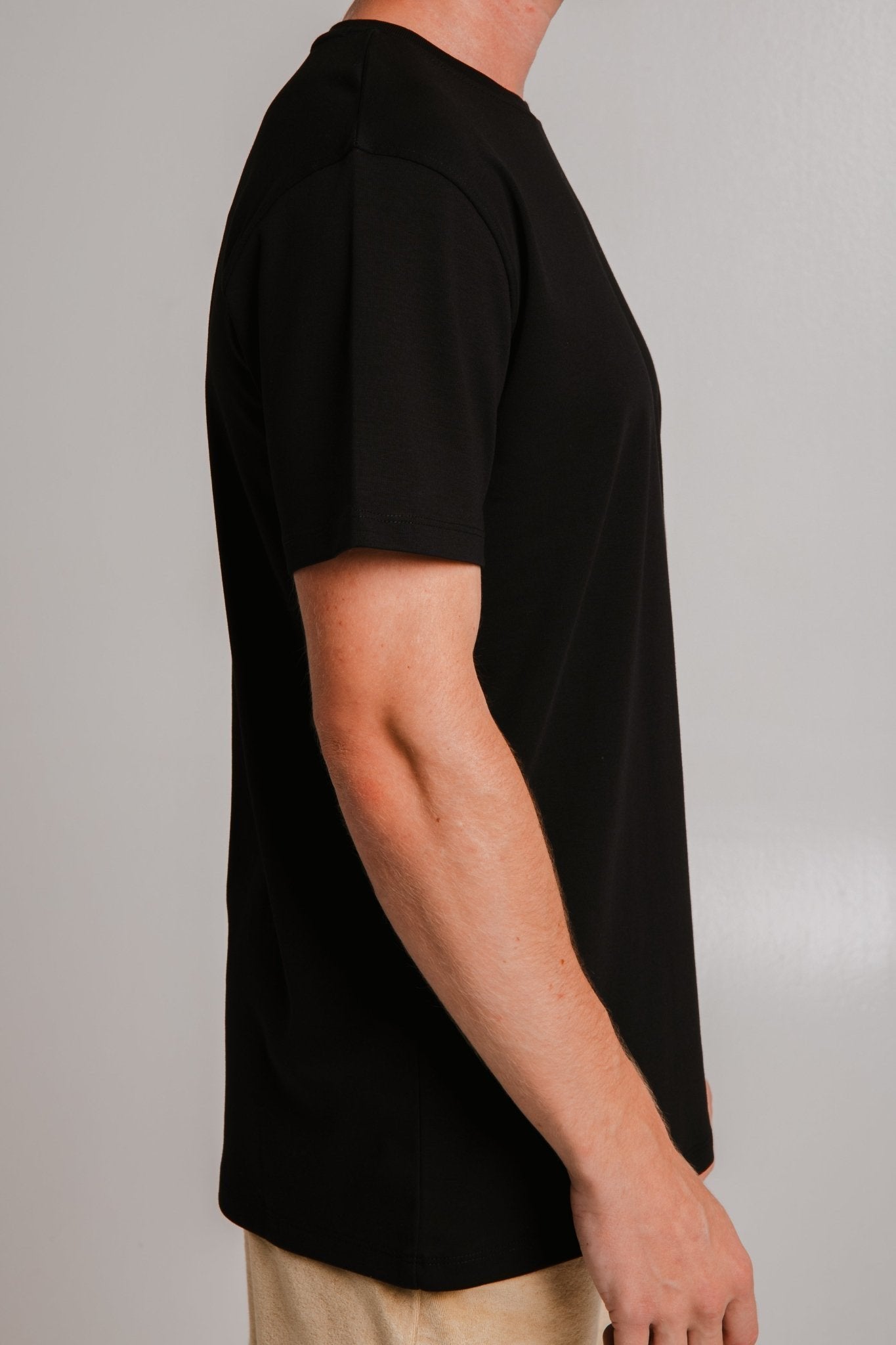 3. Side view of Sossu black heavy t-shirt on male model in studio