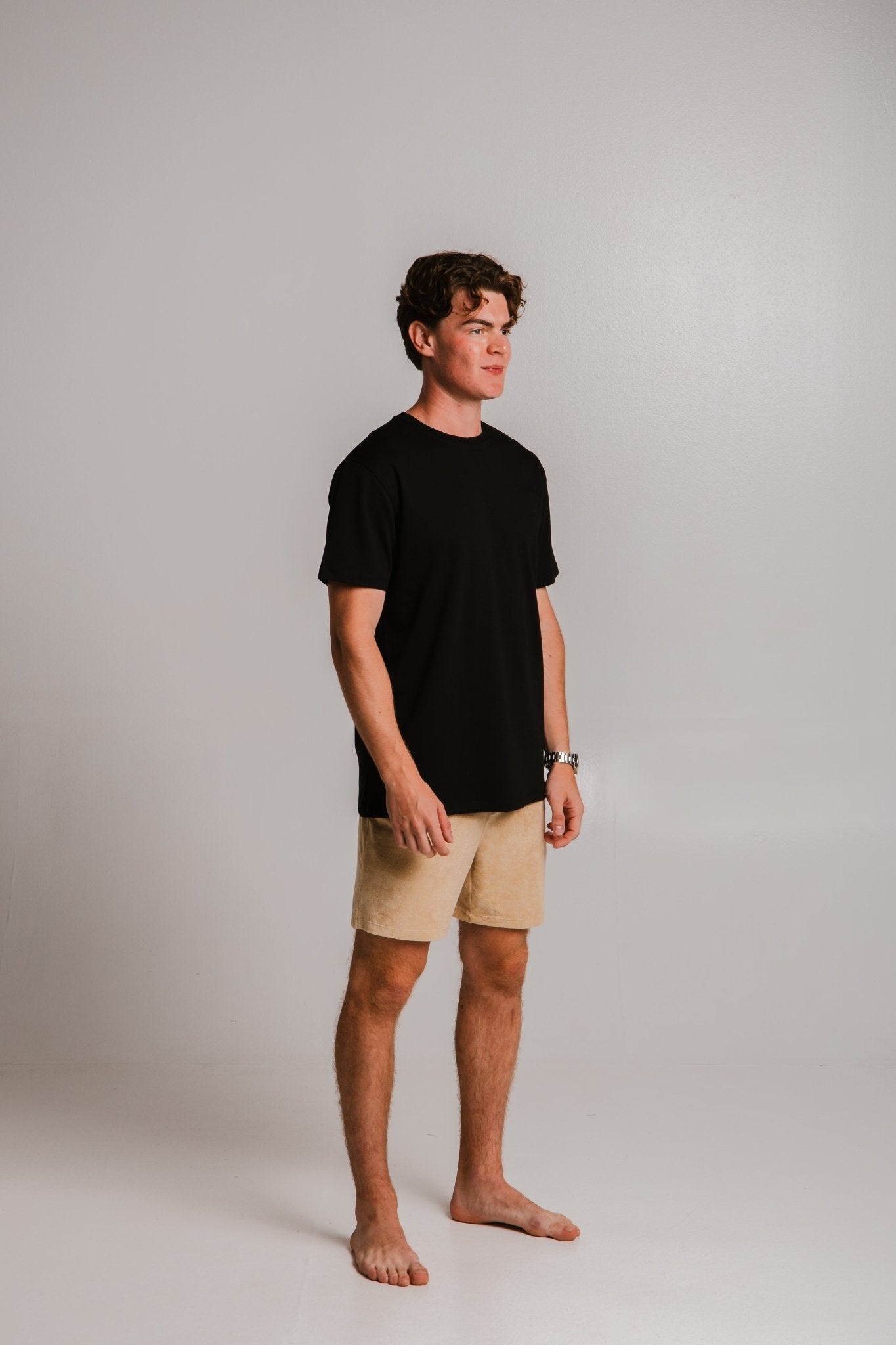 1. Unisex black heavy t-shirt by Sossu worn by male model in studio setting