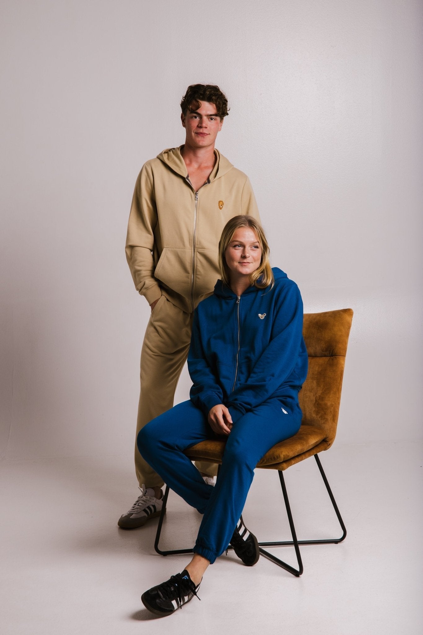 1. Unisex Lion Soft Fleece Full Zip Hoodie in light brown worn by male model, paired with blue hoodie on female model, studio setting