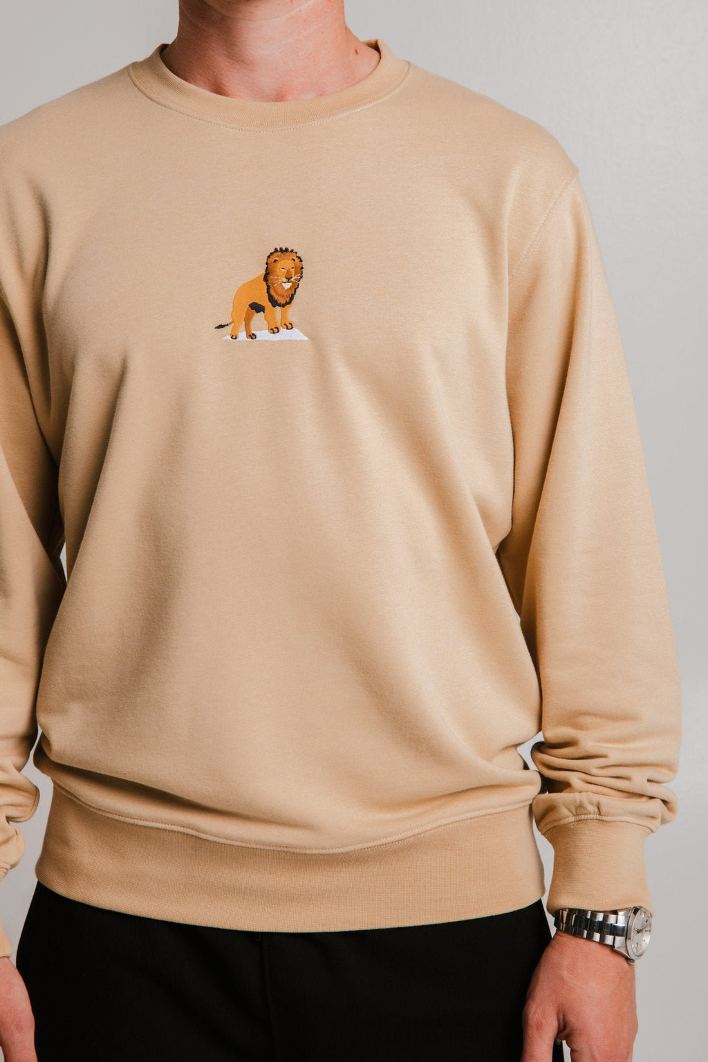 4. Close-up of unisex light brown Lion Soft Fleece Sweatshirt by Sossu, highlighting lion embroidery