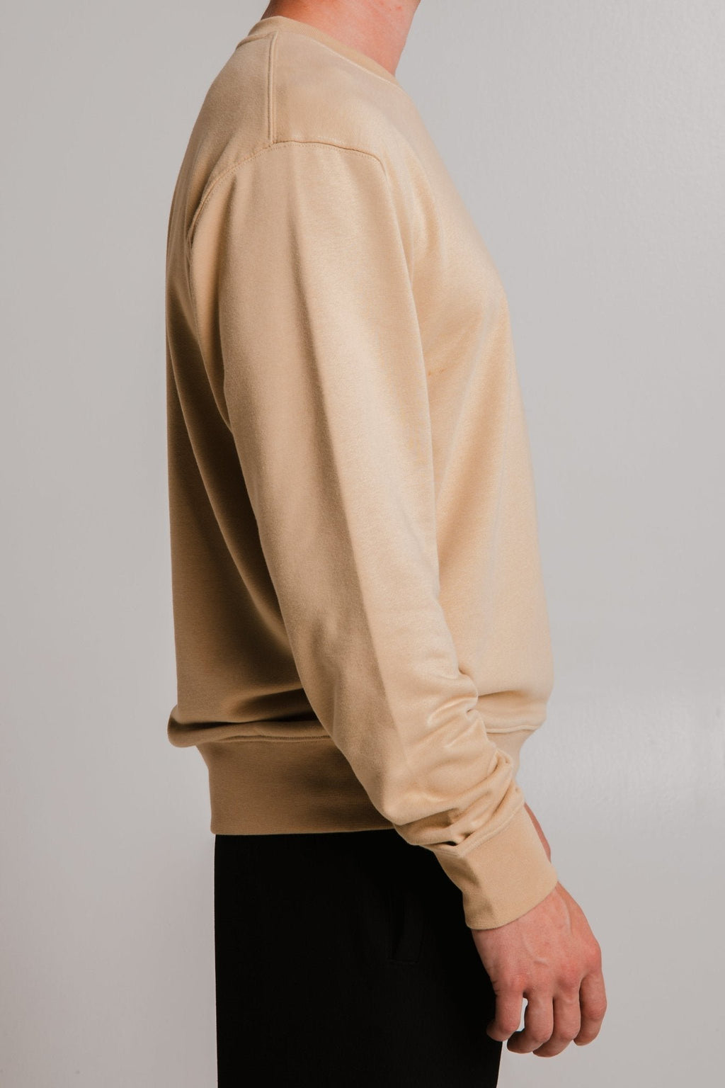 5. Side view of unisex light brown Lion Soft Fleece Sweatshirt by Sossu worn by male model in studio
