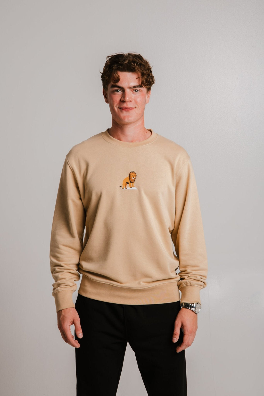 7. Unisex light brown Lion Soft Fleece Sweatshirt by Sossu worn by male model, side angle in studio