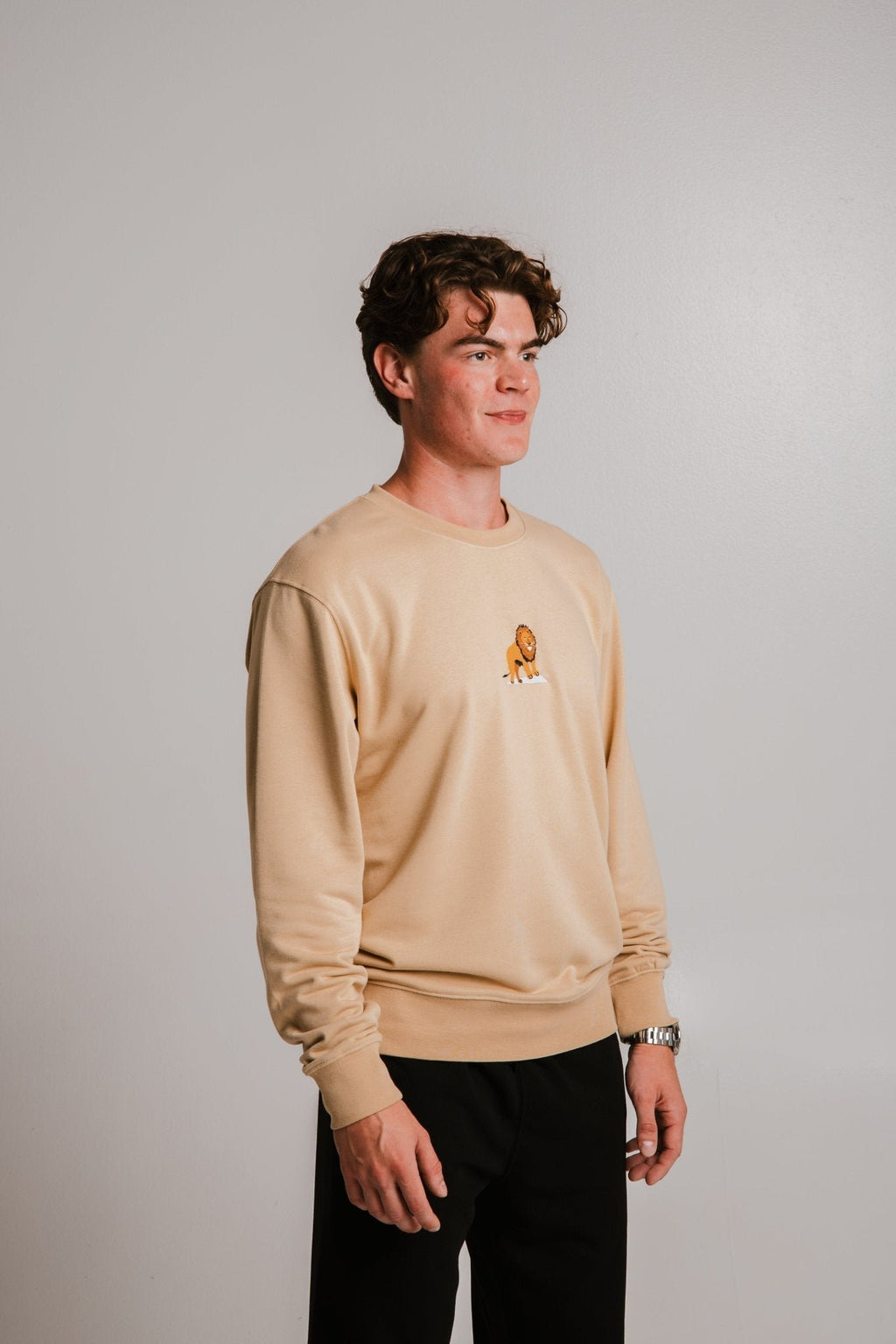 2. Unisex light brown Lion Soft Fleece Sweatshirt by Sossu worn by male model, front view in studio