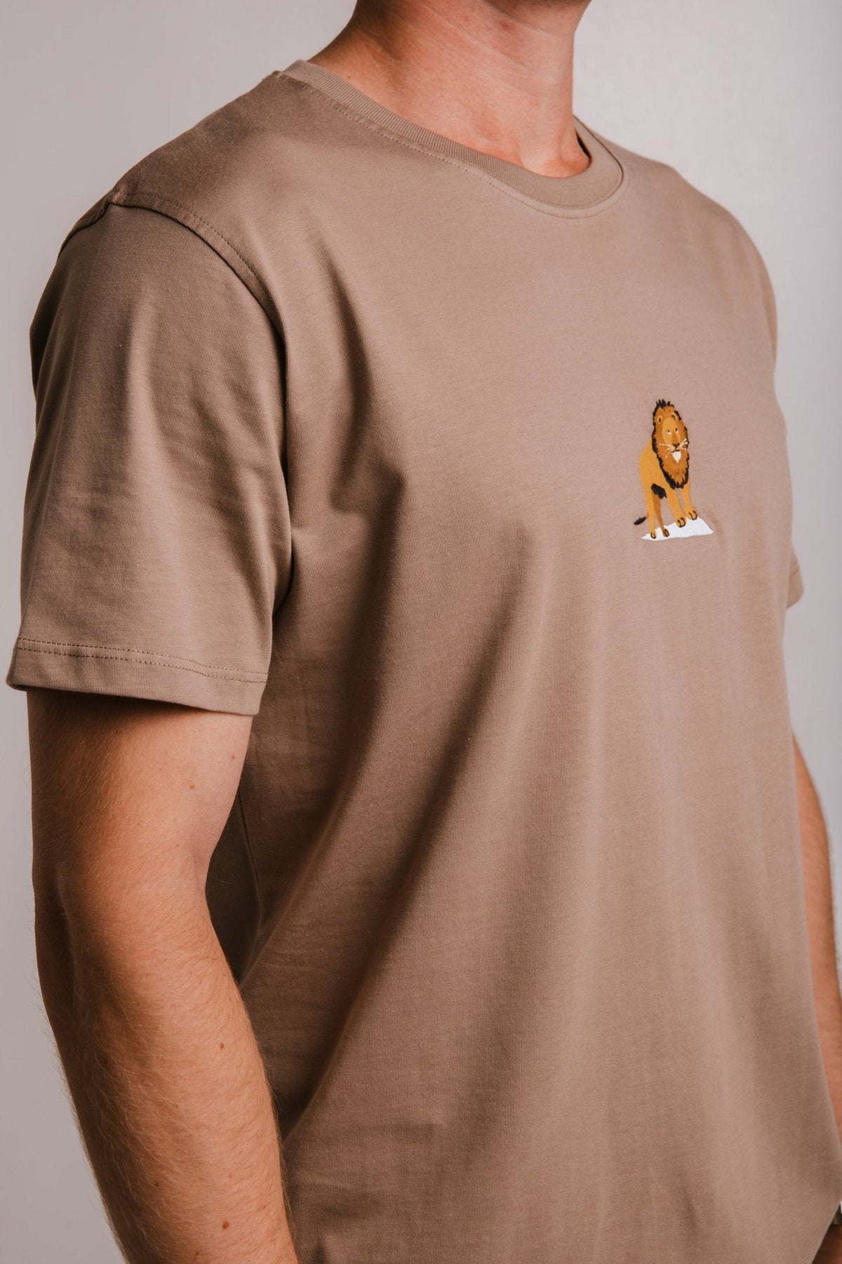 3. Side view of Sossu Lion T-shirt in Milky Brown, showing embroidered lion detail and regular fit