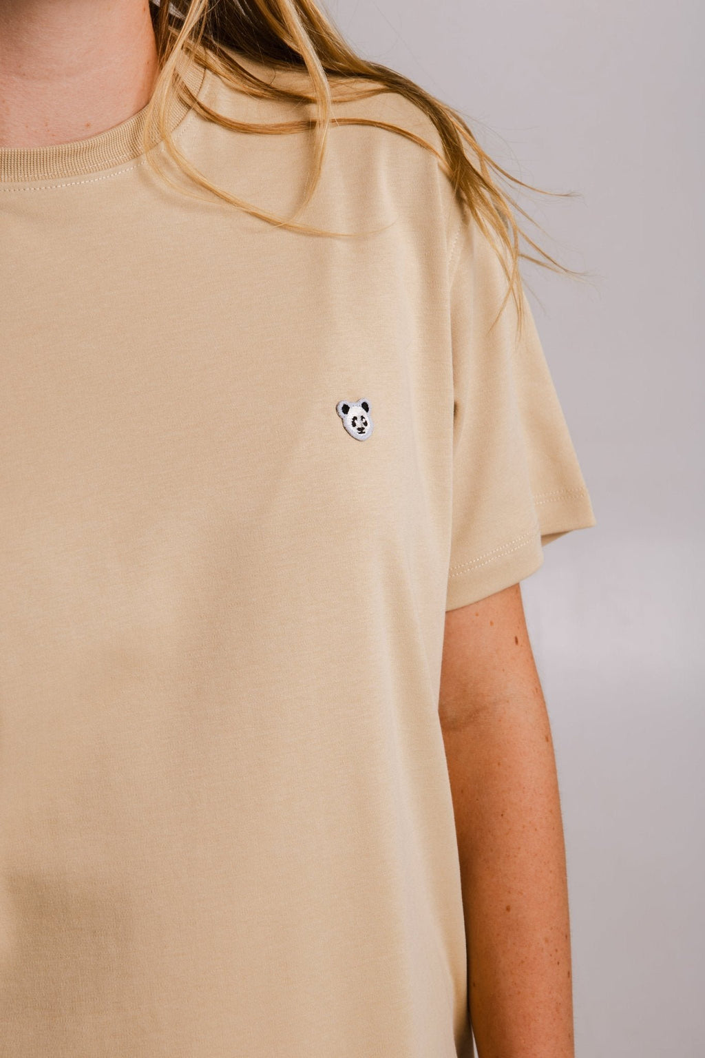 3. Close-up of embroidered panda design on Sossu's light brown heavy t-shirt