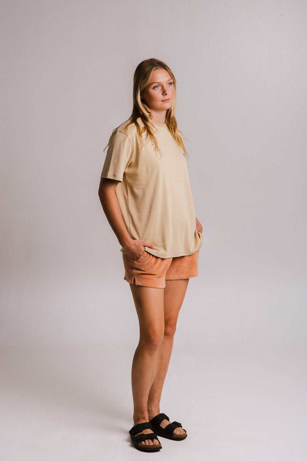 5. Women's Panda Heavy T-shirt in light brown by Sossu, styled with shorts and sandals in a studio setting