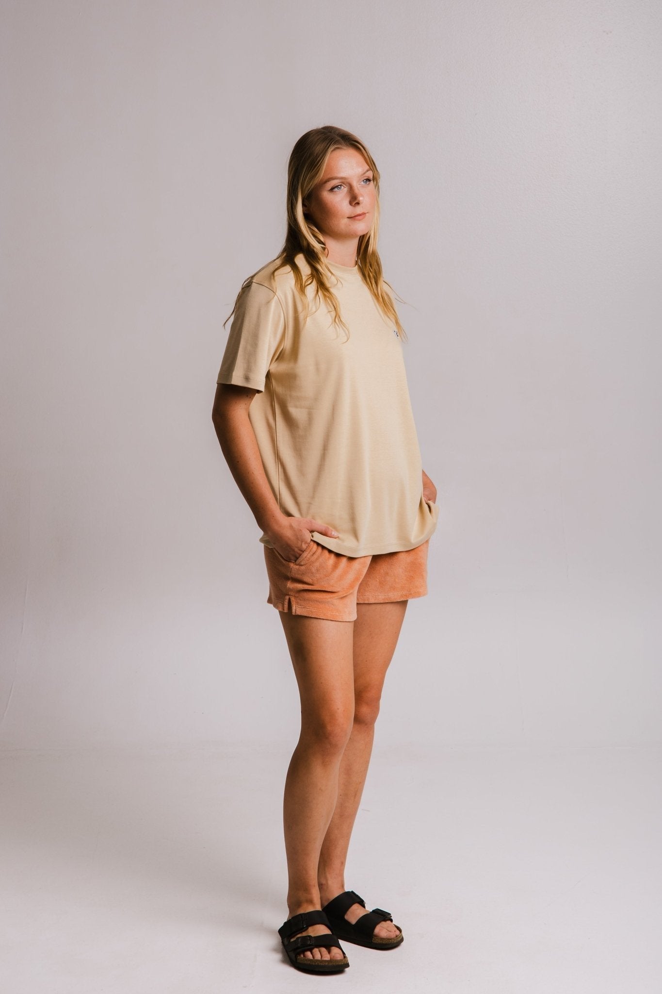 5. Women's Panda Heavy T-shirt in light brown by Sossu, styled with shorts and sandals in a studio setting