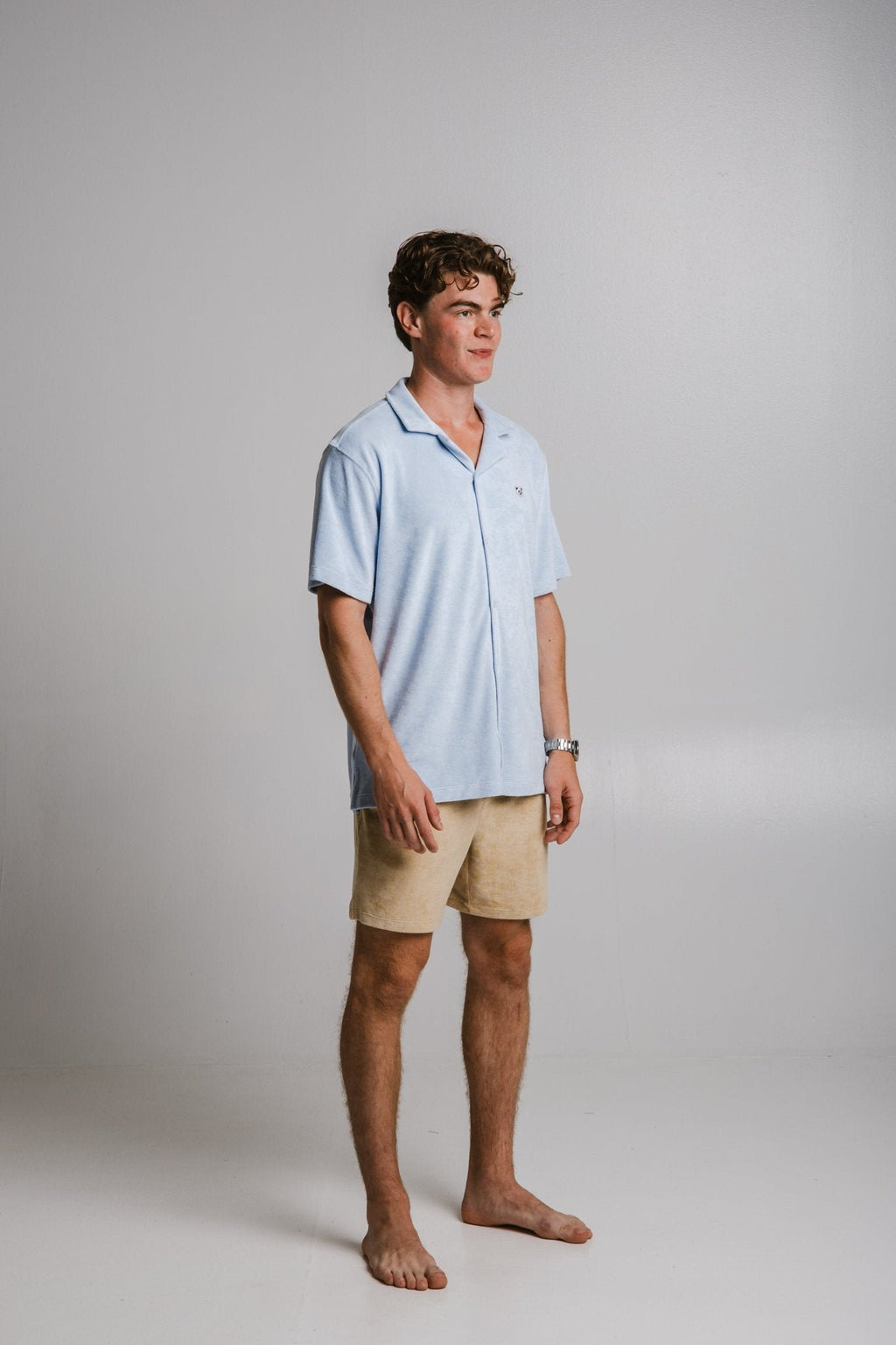 2. Side view of men's light blue Panda Terry Shirt by Sossu, styled with beige shorts