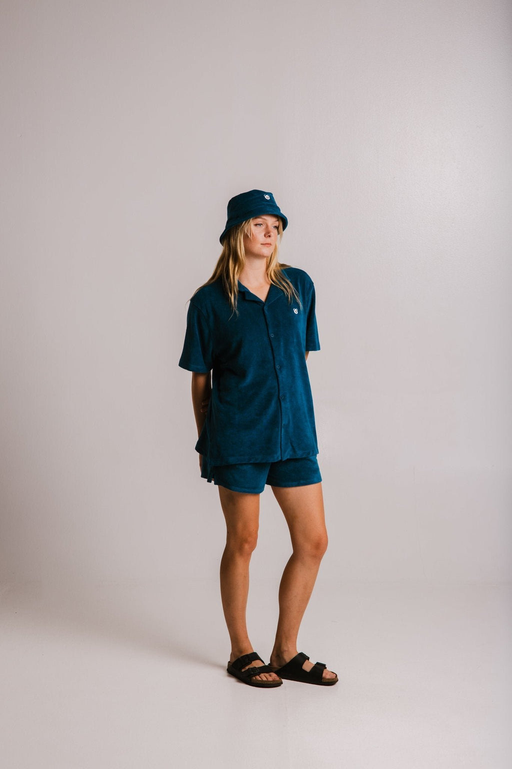 3. Full view of women's unisex navy blue Panda Terry Shirt by Sossu, paired with matching shorts and bucket hat in studio