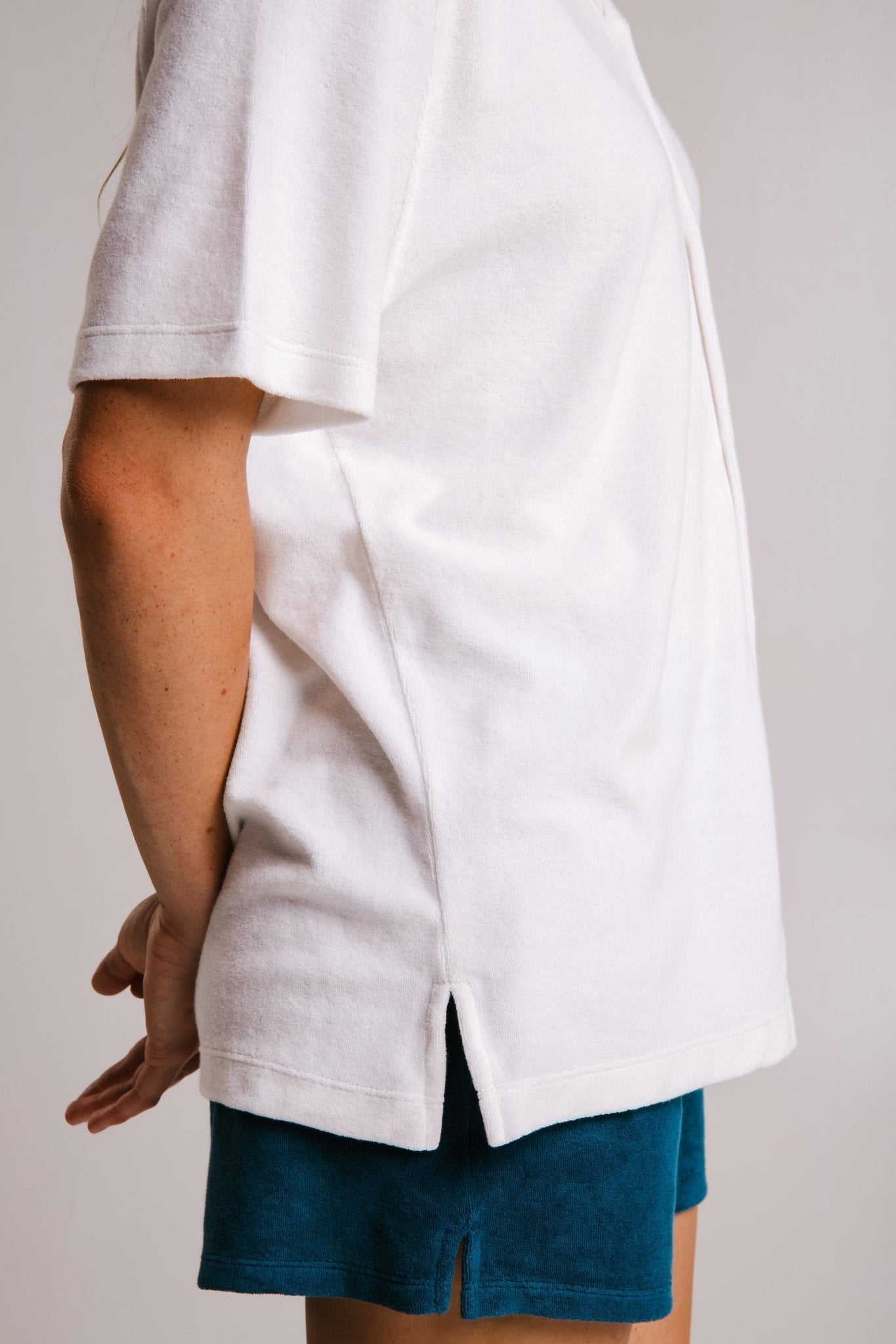5. Close-up side view of women's white Panda Terry Shirt by Sossu, highlighting the hem and fabric texture