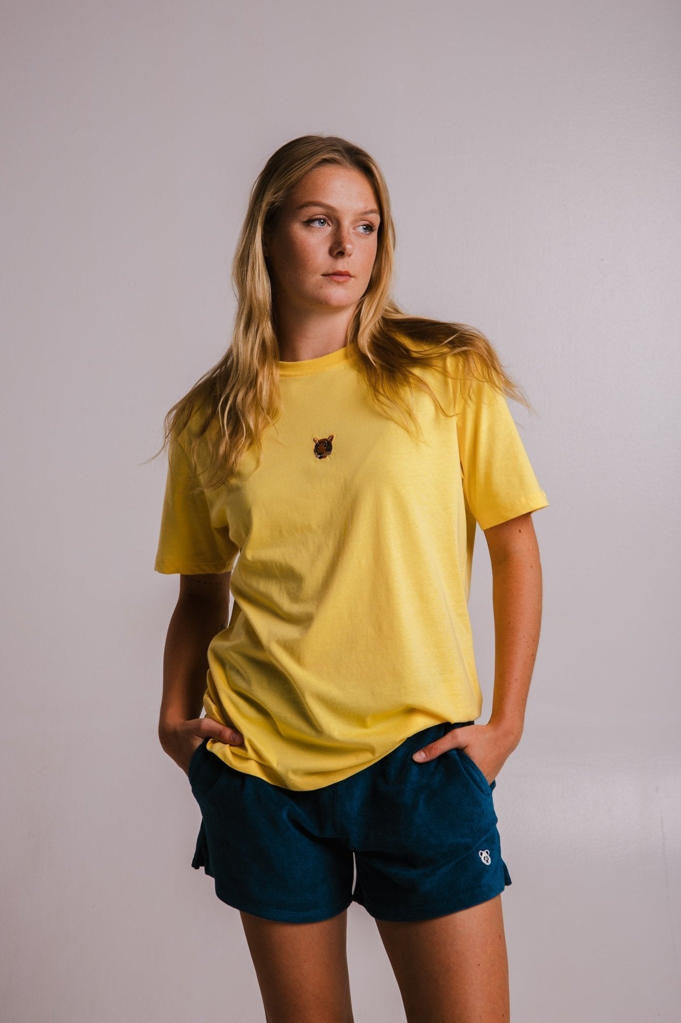 2. Women's yellow Tiger T-shirt by Sossu, styled with blue shorts in studio